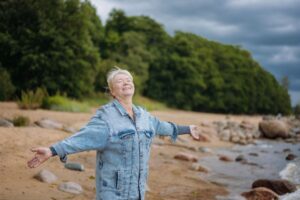 happy senior woman enjoying life and summer on the beach