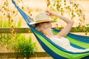 Tired mother tries to sleep in hammock in garden